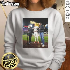 Daniel Susac of the San Francisco Giants having water thrown on him while wearing a sweatshirt during a game celebration.