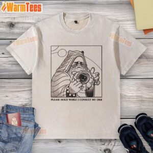 Good Please Hold While I Consult My Orb washed t-shirt design featuring a whimsical graphic and vibrant colors.