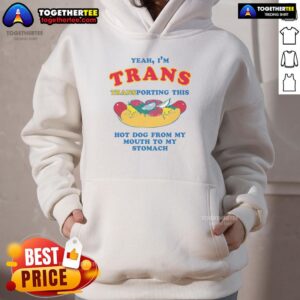 Person wearing 'Nice Yeah I'm Trans' hoodie, humorously transporting a hot dog from mouth to stomach, showcasing fun vibe.