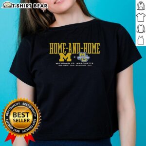 2026 Michigan Wolverines vs Marquette Golden Eagles ladies tee, featuring Ann Arbor and Milwaukee game details.