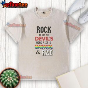 Top Rock Is Not The Devil's Work X Its Magical And Rad washed t-shirt displayed on a wooden background.