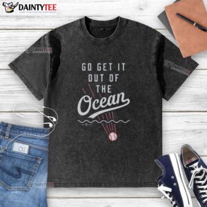 Alt Text: Nice Go Get It Out Of The Ocean washed t-shirt displayed on a wooden surface, showcasing its vibrant ocean-themed design.