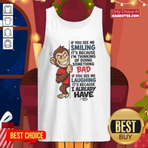 Cute monkey wearing a tank top with a playful smile, captioned 'If you see me smiling, it's because I'm thinking of doing something bad.'