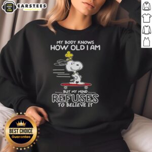 Cozy sweatshirt featuring Snoopy and Woodstock with 'My body knows how old I am, but my mind refuses to believe it' quote.