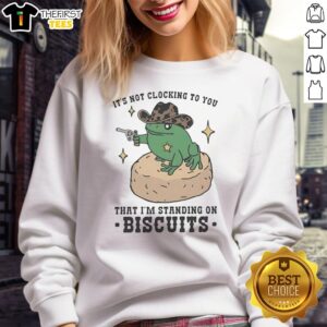 Pretty frog cowboy holding a pistol, wearing a 'It's Not Clocking to You That I'm Standing on Biscuits' sweatshirt.