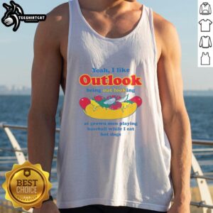 Man in a tank top enjoys hot dogs while watching grown men play baseball under a clear blue sky.