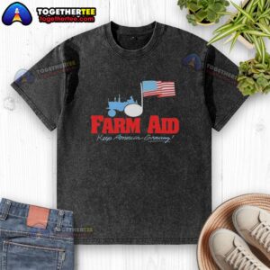 Alt Text: Premium Farm Aid Keep America Growing logo featuring a tractor and American flag on a washed t-shirt.