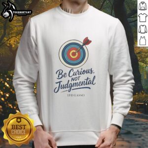 Nice Ted Lasso 'Be Curious, Not Judgmental' sweatshirt in a cozy setting, perfect for fans of the show.