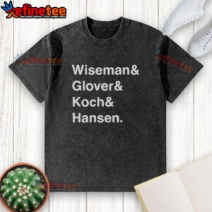 Alt Text: Official Wiseman Glover Koch Hansen washed t-shirt displayed on a wooden table, featuring a relaxed fit and soft fabric.