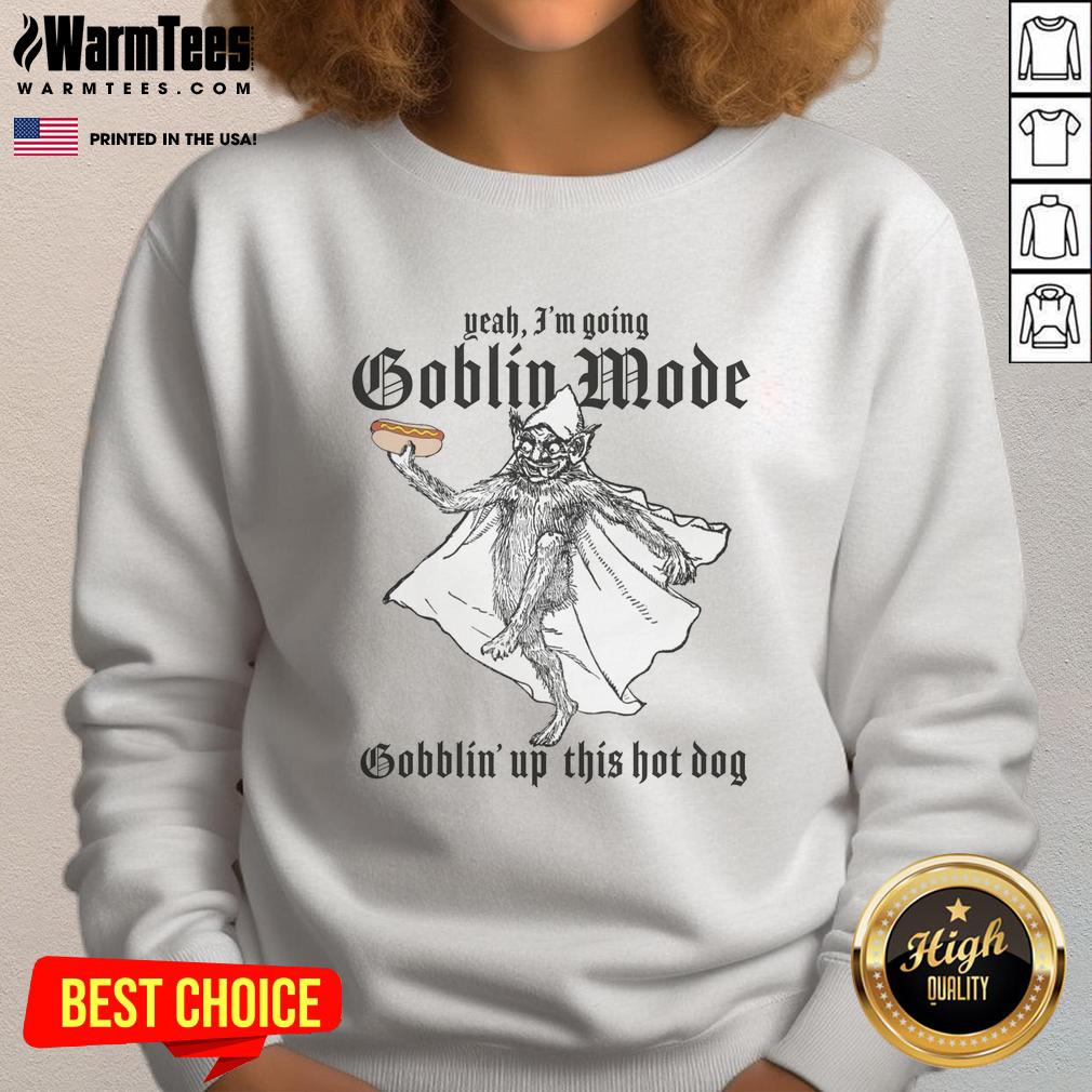 good-yeah-im-going-goblin-mode-gobblin-up-this-hot-dog-sweatshirt Person wearing 'Good Yeah Im Going Goblin Mode' sweatshirt while enjoying a hot dog at a vibrant outdoor setting.
