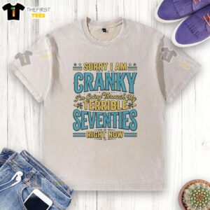 Top Sorry I Am Cranky I'm Going Through My Terrible Seventies Right Now washed t-shirt displayed on a hanger.