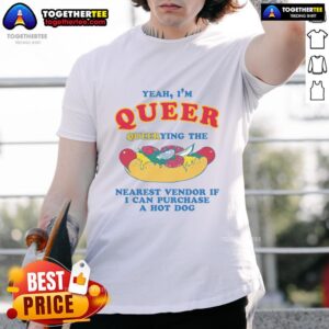Person in a 'Nice Yeah Im Queer' shirt asking a vendor about purchasing a hot dog t-shirt at a street fair.
