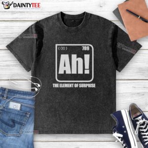 Nice-Ah The Element Of Surprise washed t-shirt displayed on a wooden table, showcasing its soft fabric and vibrant design.