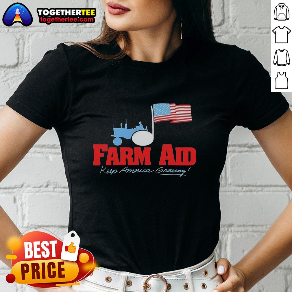 Premium Farm Aid Keep America Growing The Logo Of A Tractor And The American Flag Ladies-Tee Alt Text: Premium Farm Aid Keep America Growing logo featuring a tractor and American flag on a ladies tee shirt.