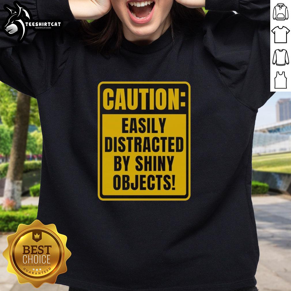 top-caution-easily-distracted-by-shiny-objects-sweatshirt Alt Text: Top Caution Easily Distracted By Shiny Objects Sweatshirt in vibrant colors, perfect for fun and unique fashion statements.