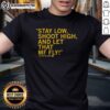 Alt Text: Top Taylor McCabe 'Stay Low Shoot High And Let That Mf Fly' T-Shirt featuring bold typography on a stylish background.