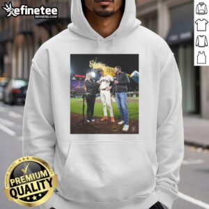 Daniel Susac in a San Francisco Giants hoodie, as water is playfully thrown on him during a fun team celebration.