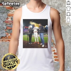 Top Daniel Susac of the San Francisco Giants throws water on a fan in a tank top during a lively game celebration.