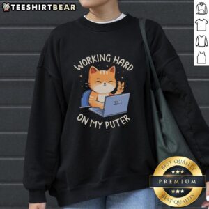 Person wearing a 'Good Working Hard On My Puter' sweatshirt while typing on a laptop at a cozy desk setup.