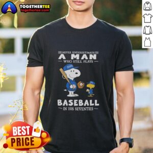 Alt Text: Peanuts X Texas Rangers T-shirt featuring 'Never Underestimate A Man Who Still Plays Baseball In His Seventies' design.