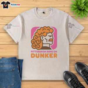 Top Pittsburgh Runs on Dunker Style Dunkin Donut washed t-shirt displayed on a hanger against a vibrant background.