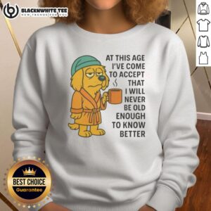 Sleepy dog in a robe holding a coffee mug, wearing a 'Never Old Enough to Know Better' sweatshirt.