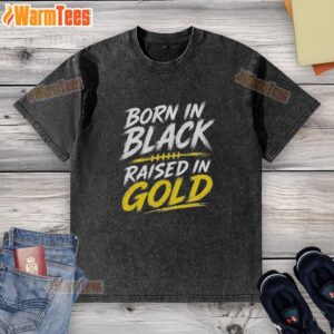 Pretty Born In Black Raised In Gold washed t-shirt displayed on a wooden background, showcasing its stylish design.