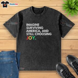 Alt Text: Pretty Imagine Surviving America and Still Choosing Joy washed t-shirt in soft cotton, featuring a vibrant graphic design.