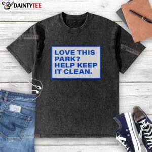 Official Love This Park Help Keep It Clean washed t-shirt displayed on a wooden background with park-themed graphics.