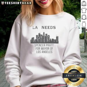 Spencer Pratt wearing a 'Los Angeles Needs Cityscape' sweatshirt against a vibrant LA cityscape background.