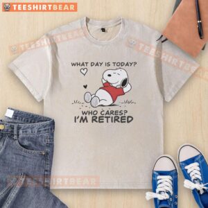 Alt Text: Official Snoopy sleeping on a 'What Day Is Today? Who Cares? I'm Retired' washed t-shirt design.
