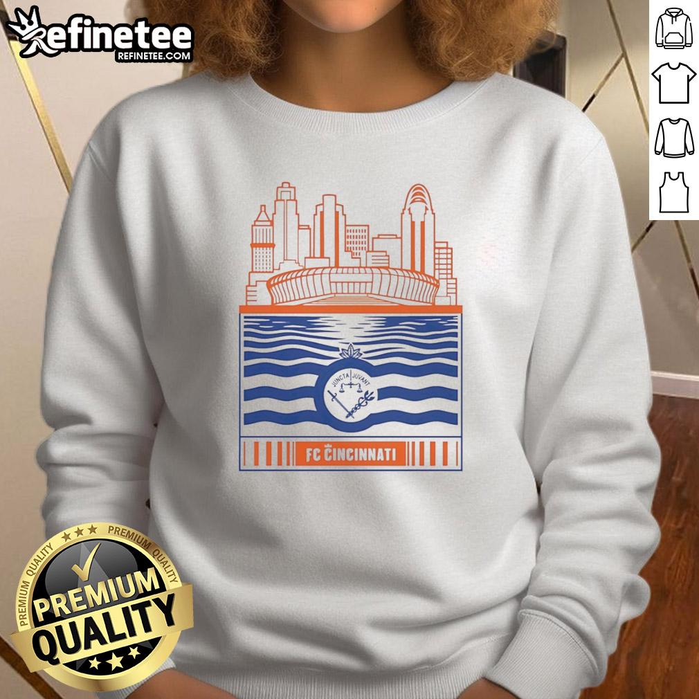 official-fc-cincinnati-city-skyline-stadium-with-river-and-logo-retro-sweatshirt Alt Text: Retro sweatshirt featuring the FC Cincinnati logo with a city skyline and river view in the background.