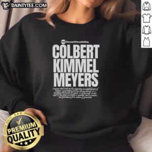 Alt Text: Hot USA 'The World Is Watching' sweatshirt featuring Colbert, Kimmel, and Meyers in a stylish design.