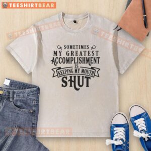 Hot 'Sometimes My Greatest Accomplishment Is Keeping My Mouth Shut' washed t-shirt displayed on a wooden table.