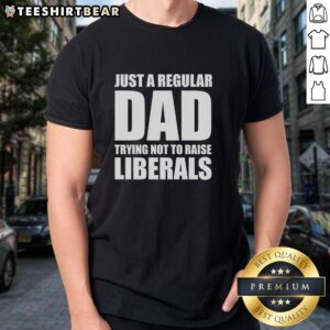 Premium 'Just A Regular Dad Trying Not To Raise Liberals' humor t-shirt for dads with a funny parenting message.
