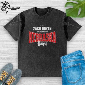 Zach Bryan performing live in concert at Nebraska Huskers, wearing a washed t-shirt, captivating the audience.