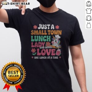 Pretty Unicorn Just A Small Town Lunch Lady WHO Serves Love One Lunch At A Time Shirt displayed on a wooden table.