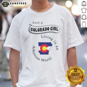 Official Just A Colorado Girl Living In An Arkansas World shirt displayed on a hanger with a scenic background