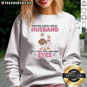 Awesome Behind Every Great Husband Is A Wife Rolling Her Eyes Duck Sweatshirt displayed on a hanger.