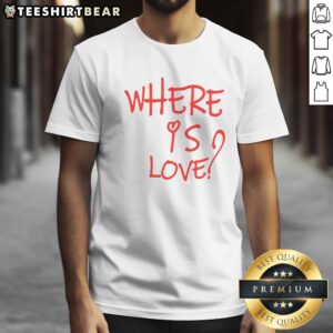 Pretty Where Is Love Red Text Shirt displayed on a wooden background, showcasing its vibrant color and unique design.