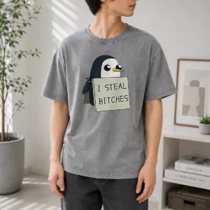 Top Gunter The Penguin I Steal Bitches Adventure Time printed on a soft washed t shirt in light gray
