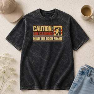 Funny Caution Low Clearance Mind The Door Frame printed on a soft washed t shirt in light gray