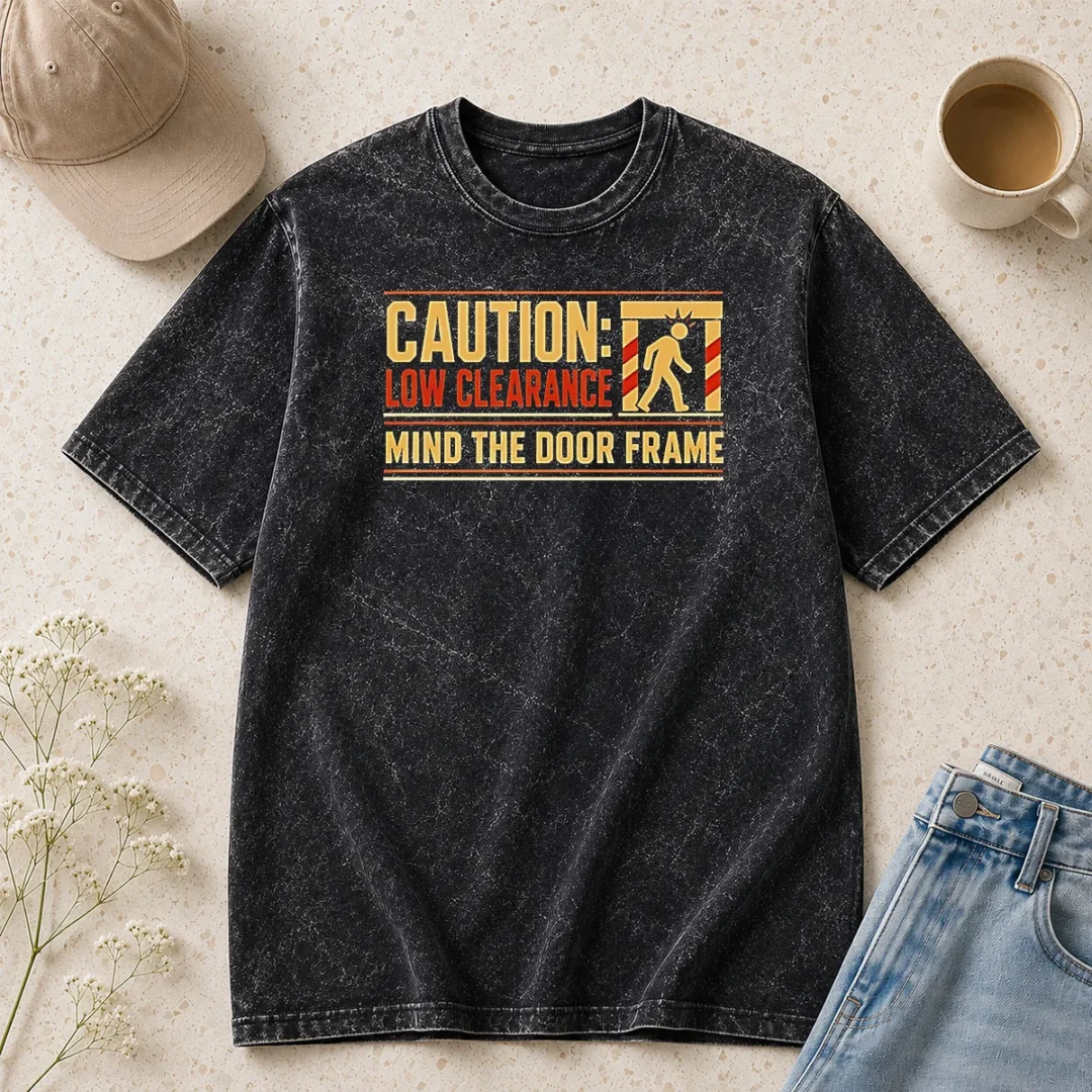 funny-caution-low-clearance-mind-the-door-frame-washed-t-shirt-1 Funny Caution Low Clearance Mind The Door Frame printed on a soft washed t shirt in light gray
