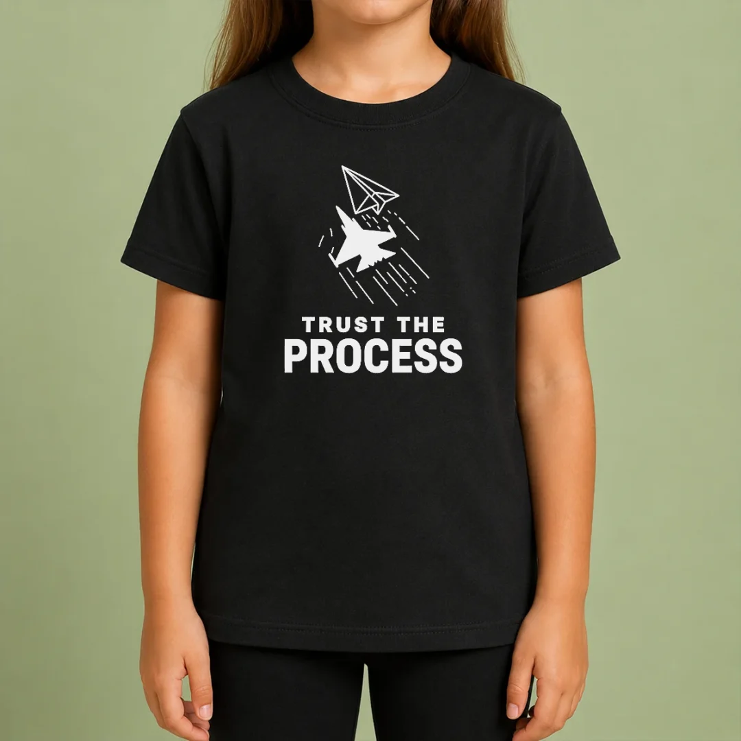 Pretty Official Trust The Process Fighter Jet Paper Airplane Kids T Shirt Pretty Official Trust The Process Fighter Jet Paper Airplane Kids T Shirt featuring a fighter jet paper airplane graphic on a children's short sleeve tee