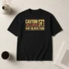 Top Official Caution Low Clearance Mind The Door Frame t shirt in black, displayed flat for clear view